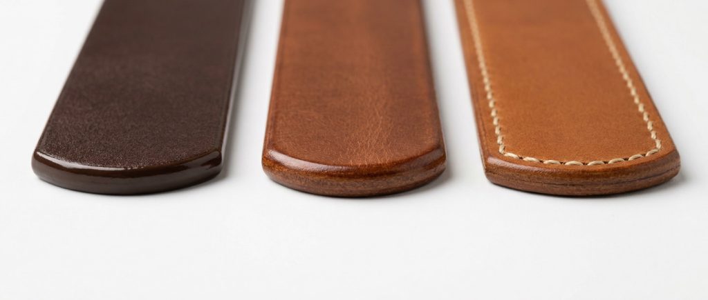 Comparison of leather belt edge finishing techniques: painted edge, burnished edge, and folded edge